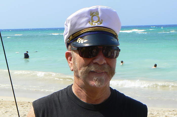 Ronnie Mund wearing a captain's hat on vacation